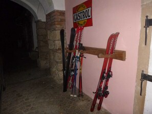 A ski rack with various skis and a sign for Castrol motor oil. - Apartment 2 1 - Apartments Manuela (Breitenstein)