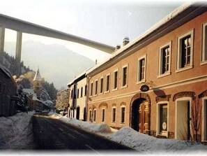 A historic building with arched doorways and a prominent entrance.