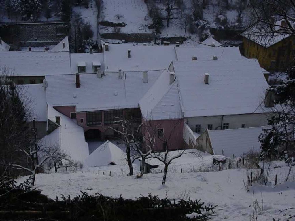 En byggnad med flera tak, en framträdande röd del och ett snötäckt landskap.