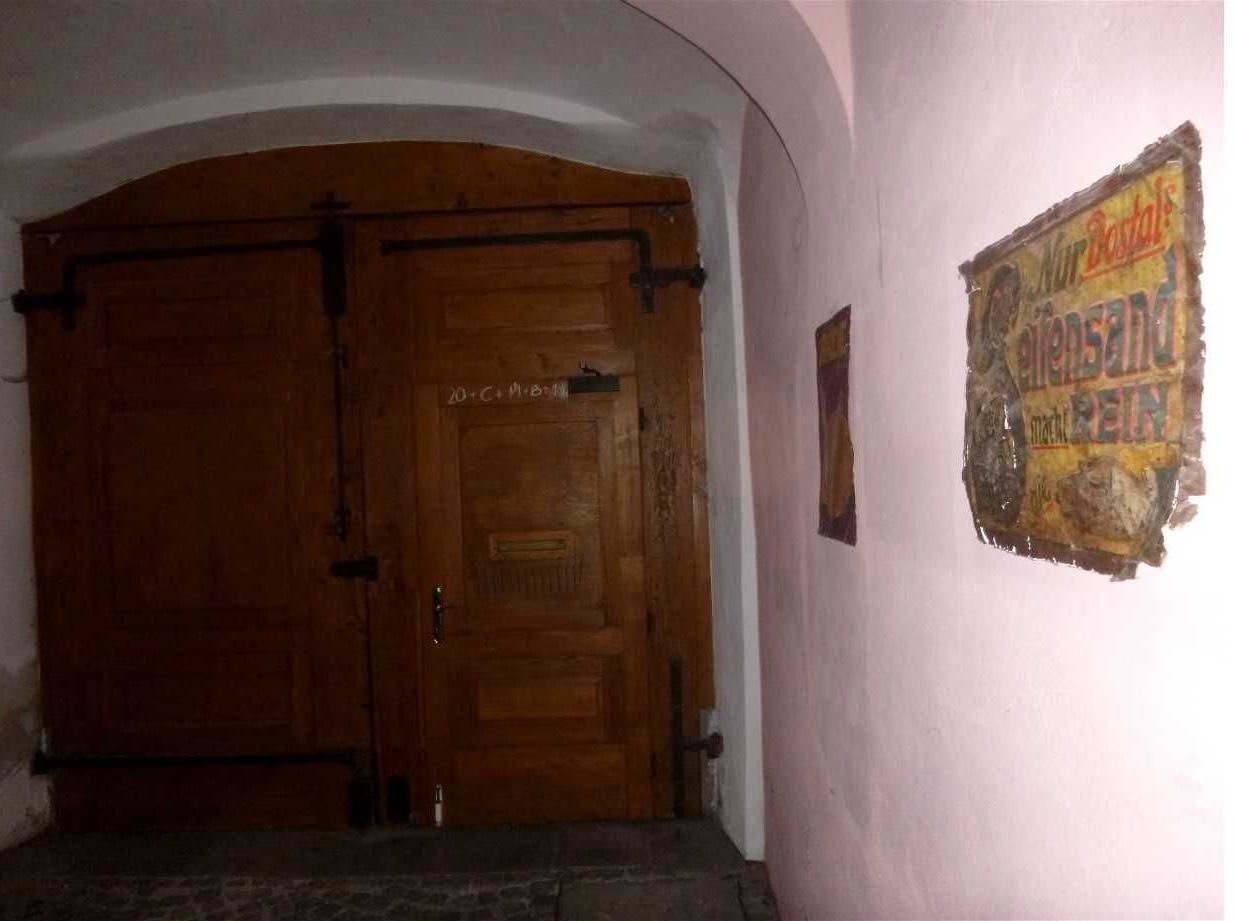 Una puerta doble de madera con un letrero encima.