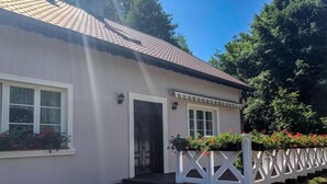 A house with a white exterior, a tiled roof, and a small porch with a white fence. - Zielona Dolina Młyn by Interhome (Kwilcz)
