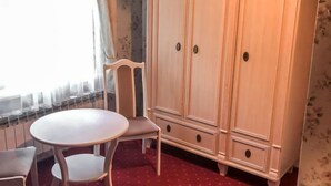 A room with a white wardrobe, a round table, and a chair. - Zielona Dolina Młyn by Interhome (Kwilcz)