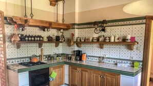 A kitchen with a stove, oven, wooden cabinets, and a tiled backsplash. - Zielona Dolina Młyn by Interhome (Kwilcz)