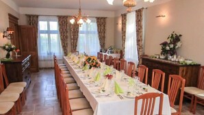 A long dining table set with chairs, a chandelier, and curtains. - Zielona Dolina Młyn by Interhome (Kwilcz)