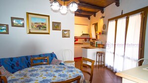 Una habitación acogedora con una cama, una mesa de comedor, sillas y una zona de cocina.
