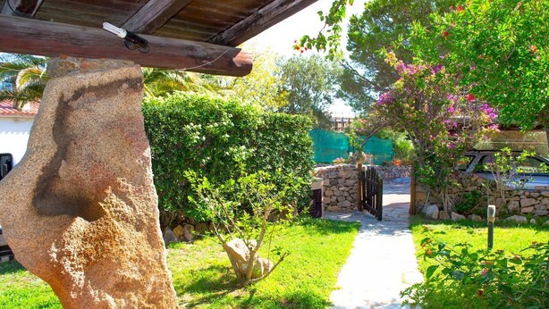 Un sendero de piedra que conduce a un edificio de piedra con techo de madera.
