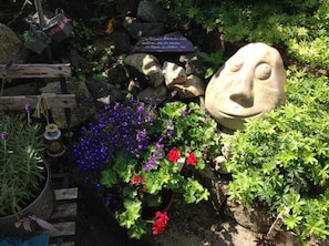 A garden with a stone sculpture, potted plants, and a wooden fence. - Neisse - Old town house/holiday apartments Görlitz (Görlitz)