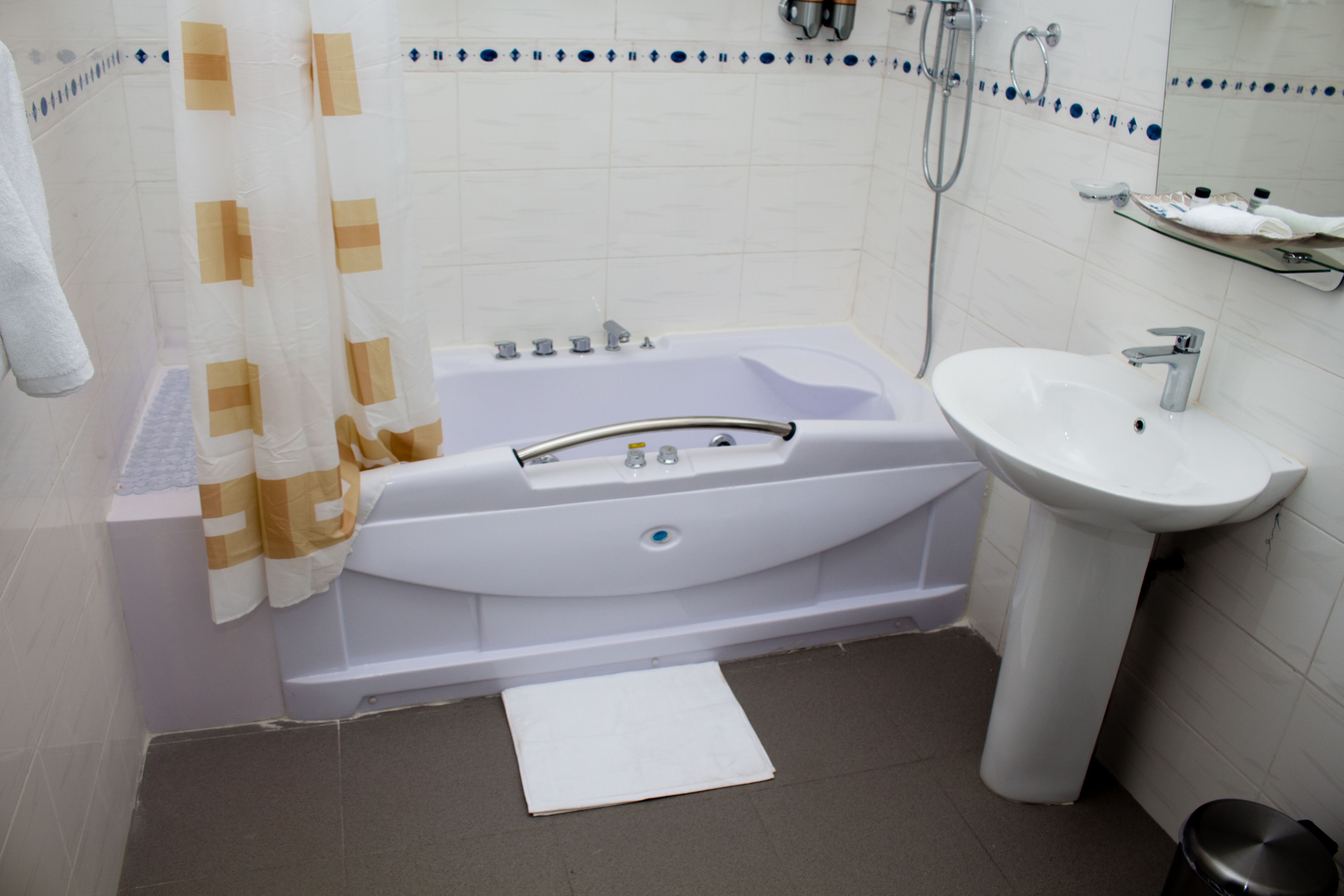 Een badkamer met een bad, een wastafel en een douche.