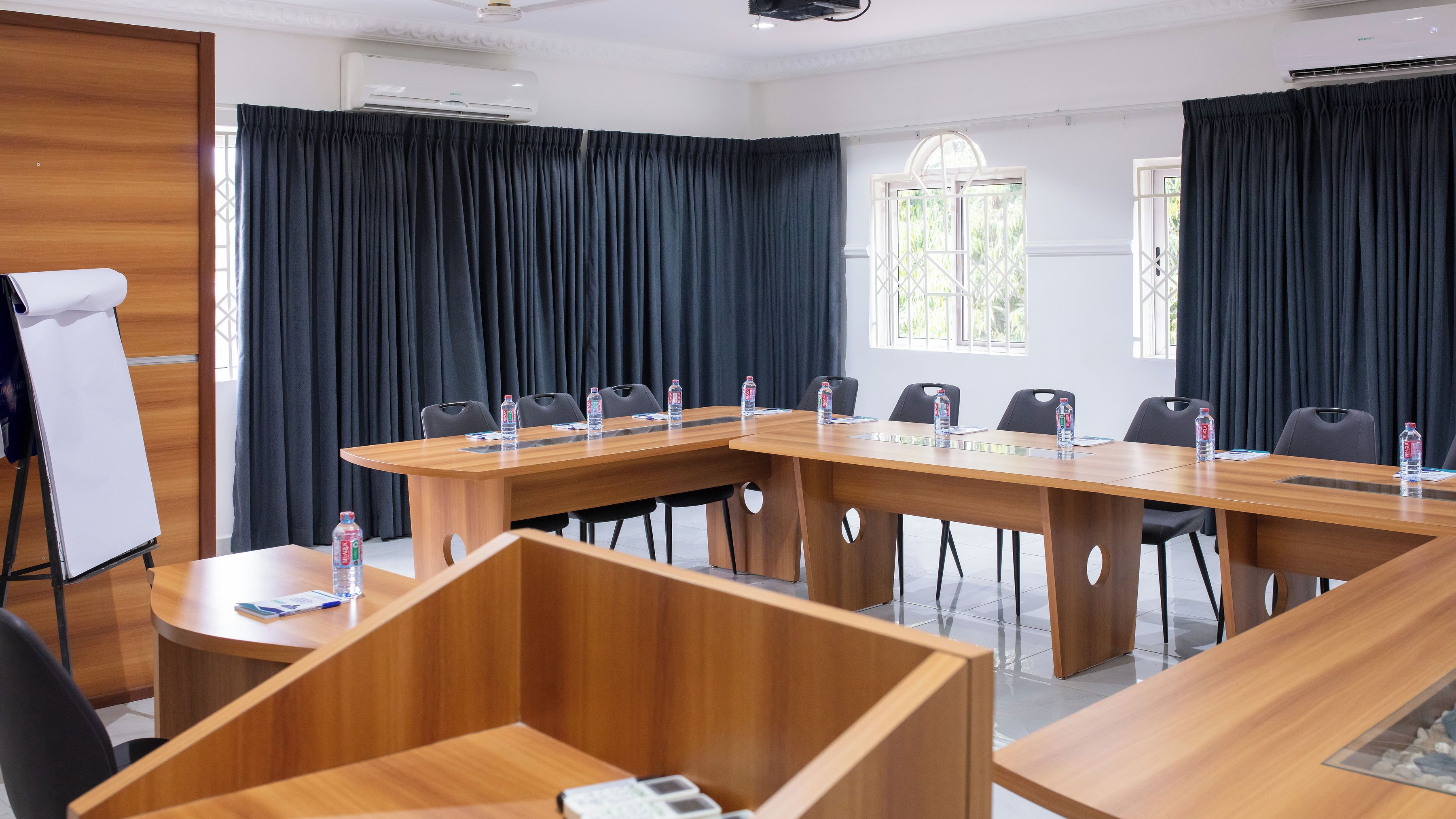 A conference room with a long table, chairs, and water bottles.