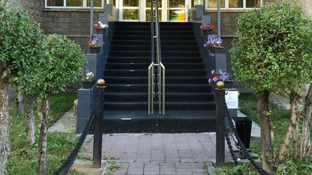 The entrance to a hostel with a sign reading "Elite HOSTEL" above the doors. There are steps leading up to the entrance, and the building has a brick facade. - Elite Hostel (Astana)