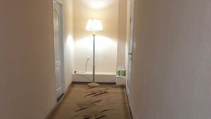 A narrow hallway with a carpet featuring a black abstract design. - Elite Hostel (Astana)