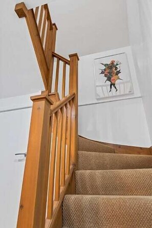 A wooden staircase with a textured carpet.