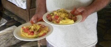 A person holding two plates of food, one with scrambled eggs and the other with a similar dish.