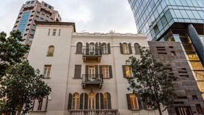A historic building with a symmetrical facade, multiple balconies, and arched windows. - Bachar House - FATTAL COLORS (Tel Aviv)