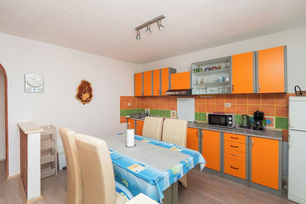 A compact kitchen with orange cabinets, a microwave, and a coffee maker.