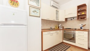 A kitchen with a refrigerator, oven, sink, and cabinets. - Apartments Luna Gordana (Razanj)