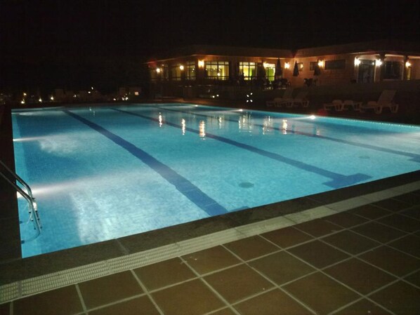 Piscina a l'aire lliure de temporada, para-sols i gandules