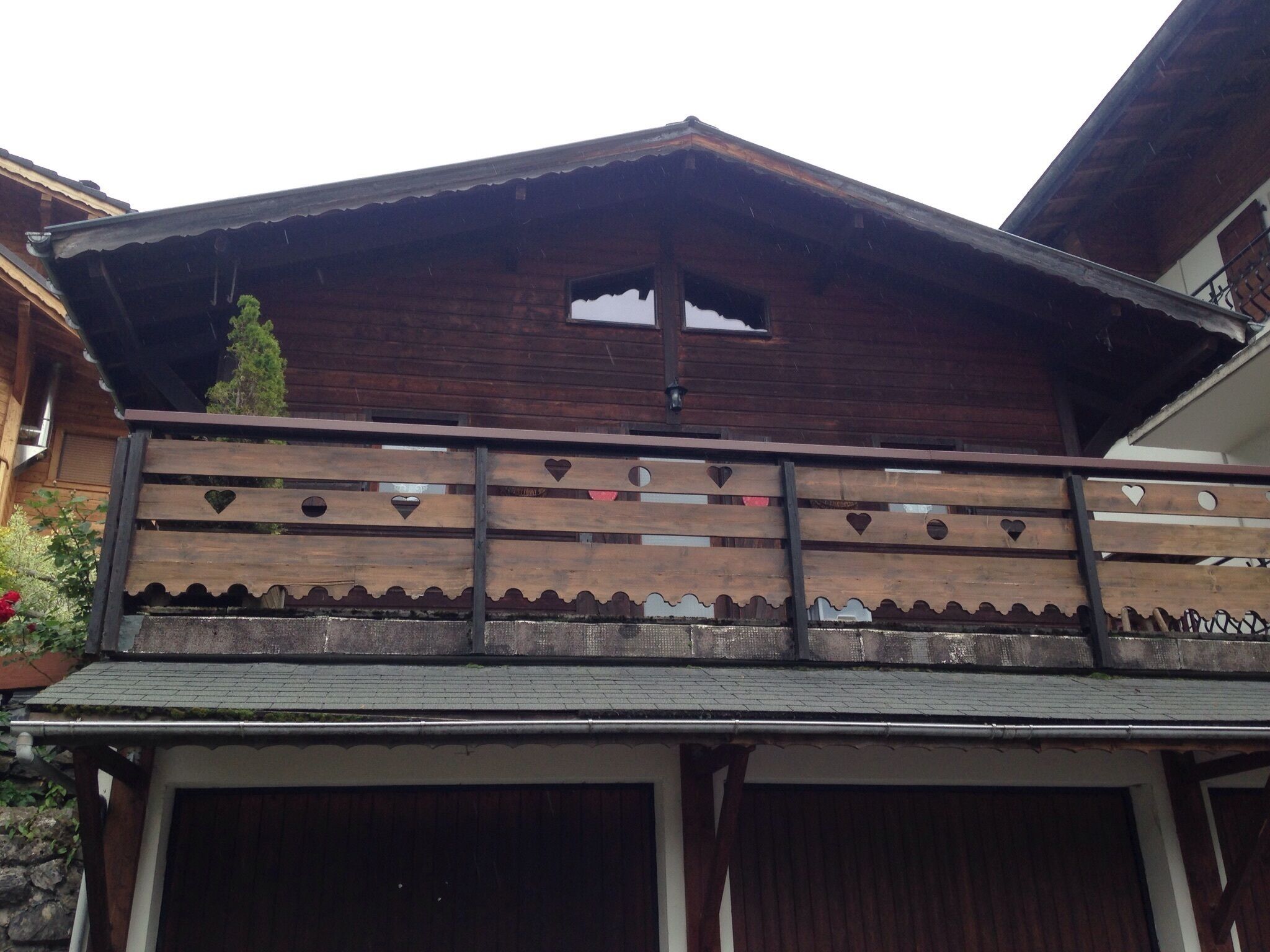 Ein Holzbalkon mit herzförmigen Ausschnitten und einem Metallgeländer.