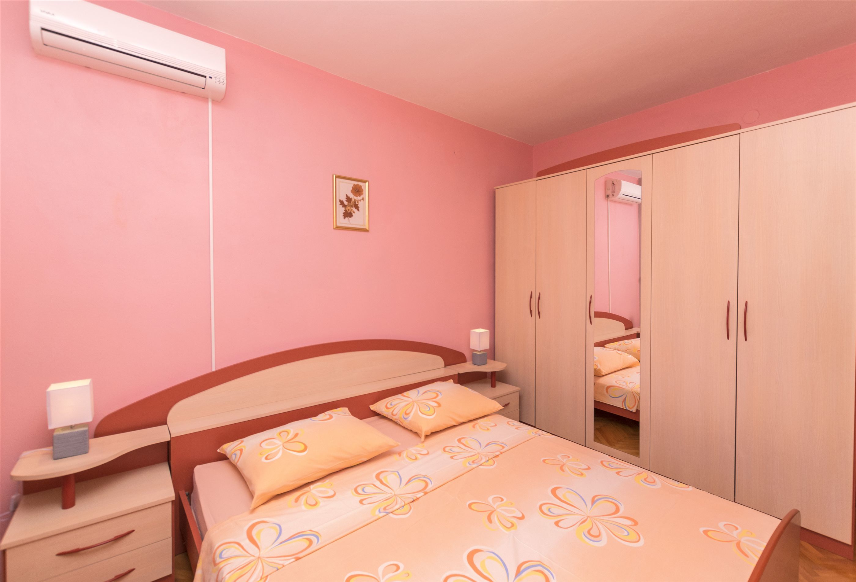 Una camera da letto con un letto, un comodino, un armadio e un condizionatore.