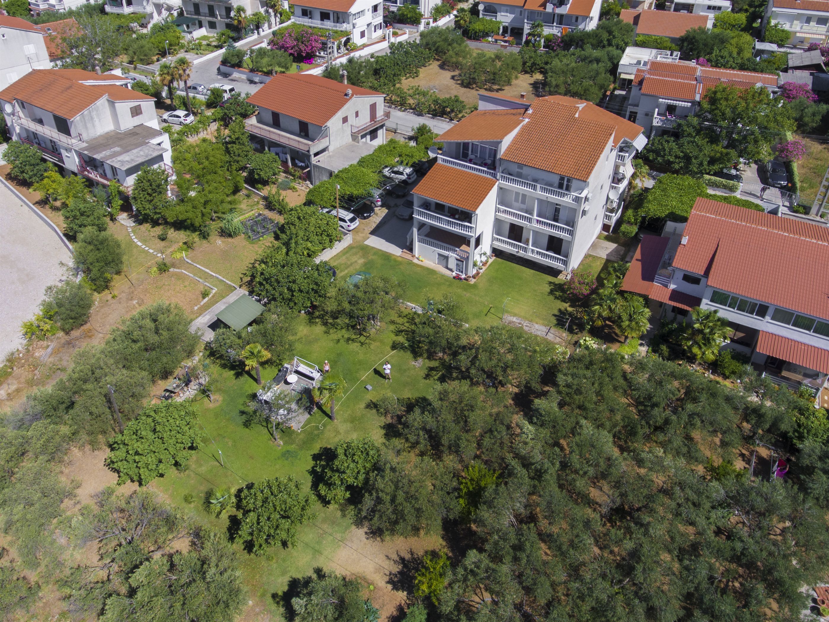 A residential area with multiple two-story houses, each featuring a balcony and a red-tiled roof.