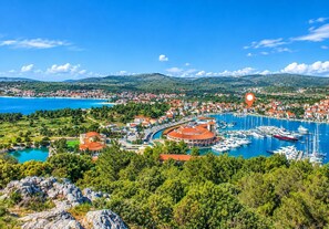 A coastal town with a marina, buildings with red roofs, and a clear blue sky. - Apartments Sime (Rogoznica)