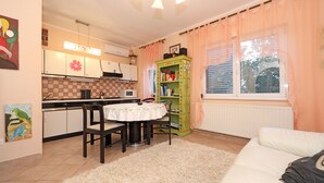 Una cocina compacta con una mesa de comedor, sillas y un armario verde.