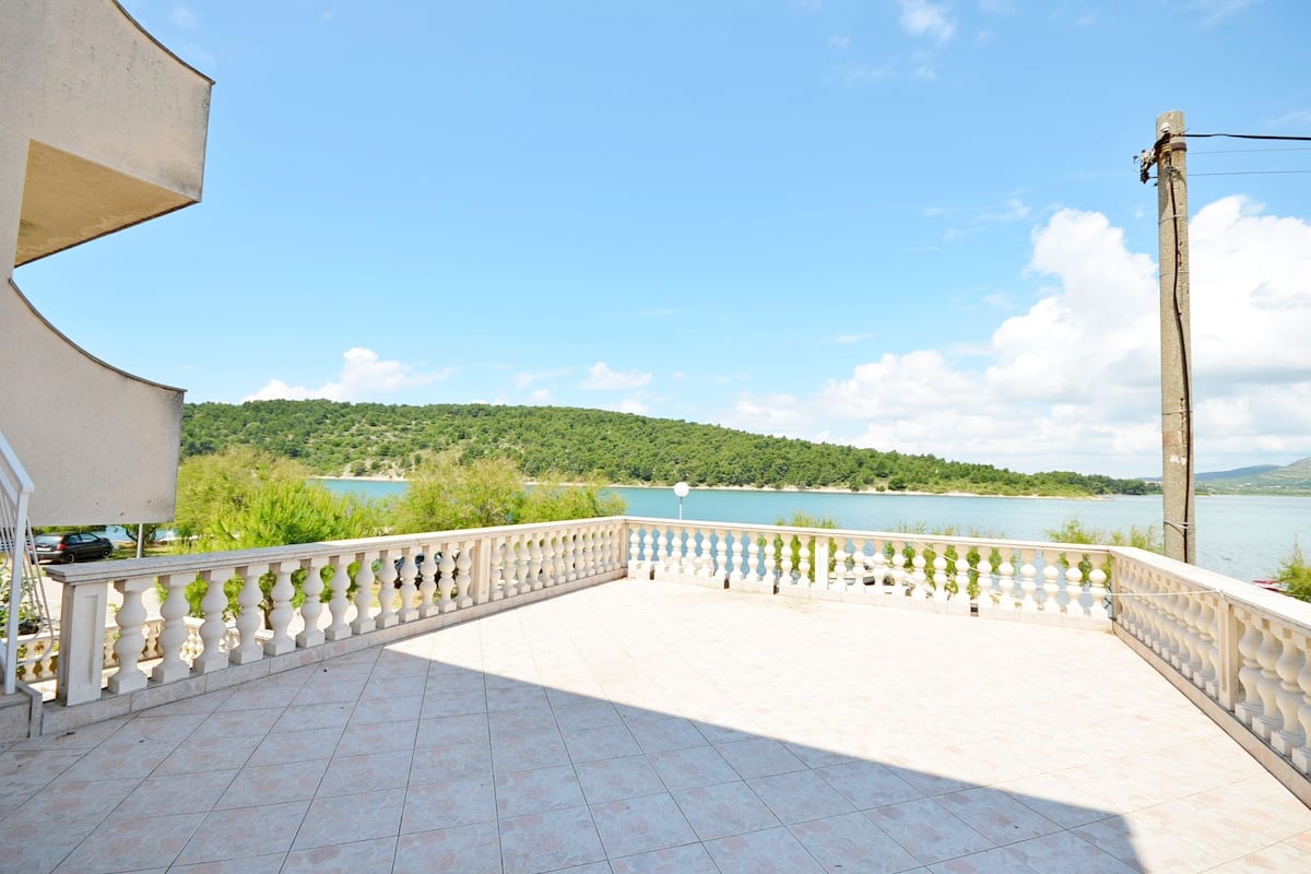 Ein Balkon mit Blick auf einen See und Hügel.