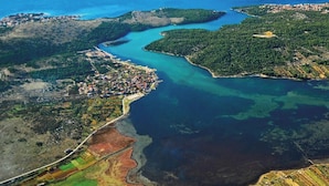 An aerial view of a coastal landscape with a river, fields, and a small town. - Apartments Vila Punta (Jadrtovac)