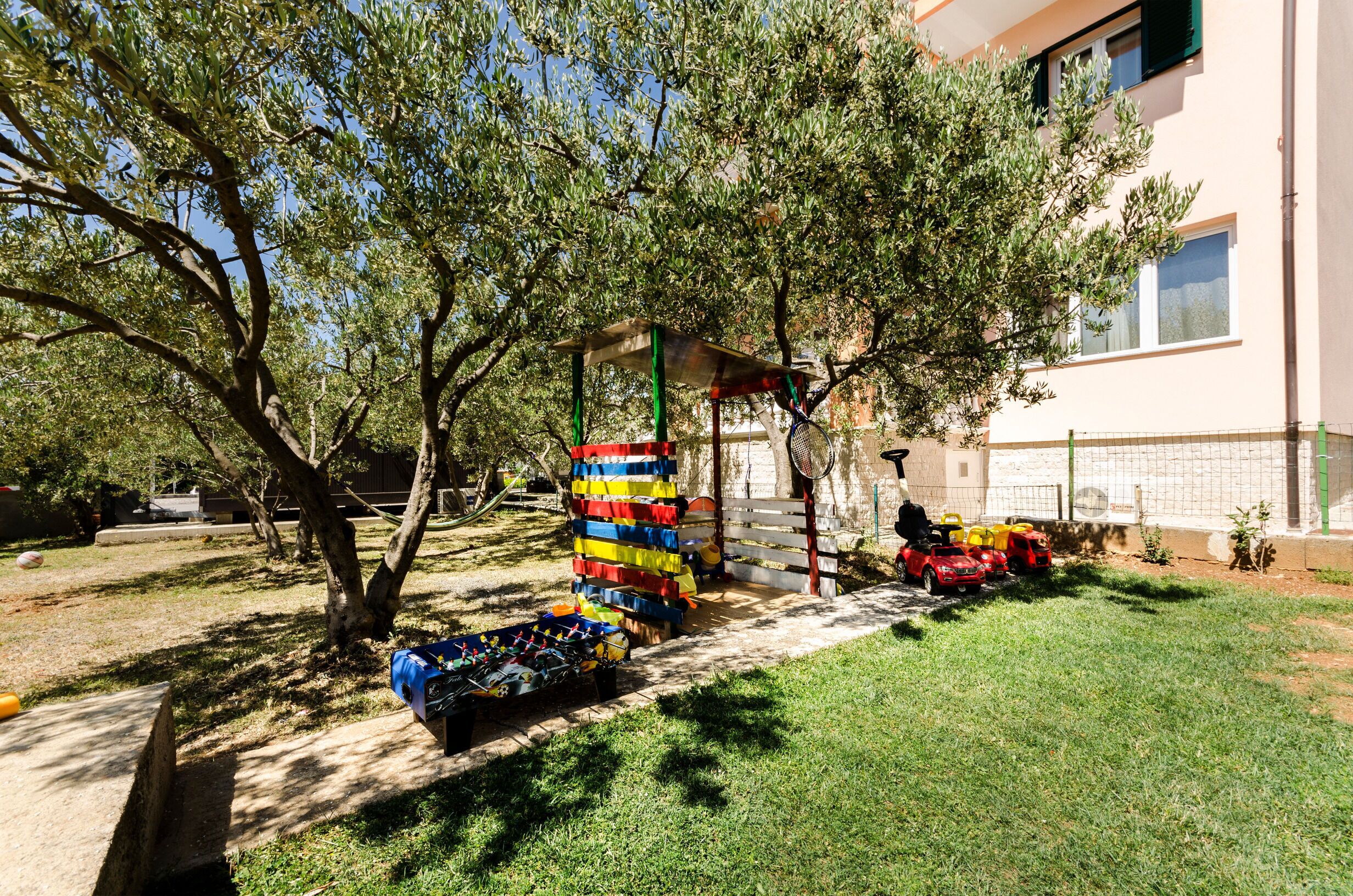 A courtyard with a play area, including a colorful play structure and toy cars.