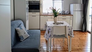 A compact living space with a kitchenette, a dining area, and a sofa. - Apartments Marija (Razanj)
