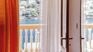 A room with a view of a body of water and buildings in the distance. - Apartments Vesna (Brna)