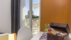 Een kamer met een houten deur, een tafel met een tafelkleed met dessin, en een kledingkast.