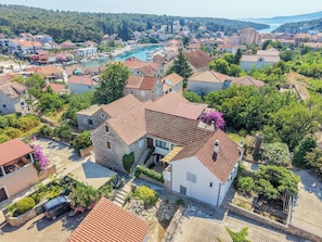 A coastal town with stone buildings, a marina, and a hilltop view.