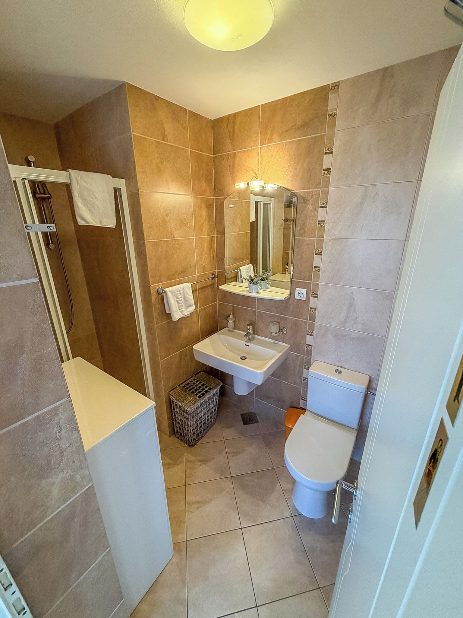A bathroom with a shower, sink, and toilet.
