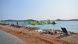 A beach with sun loungers and water toys.