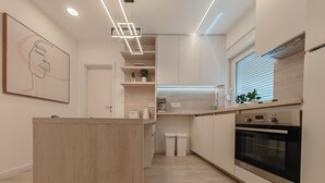 A modern kitchen with a wooden island, built-in appliances, and a minimalist design. - Apartments Mateo (Vodice)