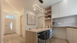A modern kitchen with a central island, a dining area with chairs, and built-in cabinets. - Apartments Mateo (Vodice)