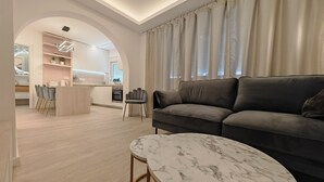A modern living room with a marble coffee table, a grey sofa, and a kitchen in the background. - Apartments Mateo (Vodice)