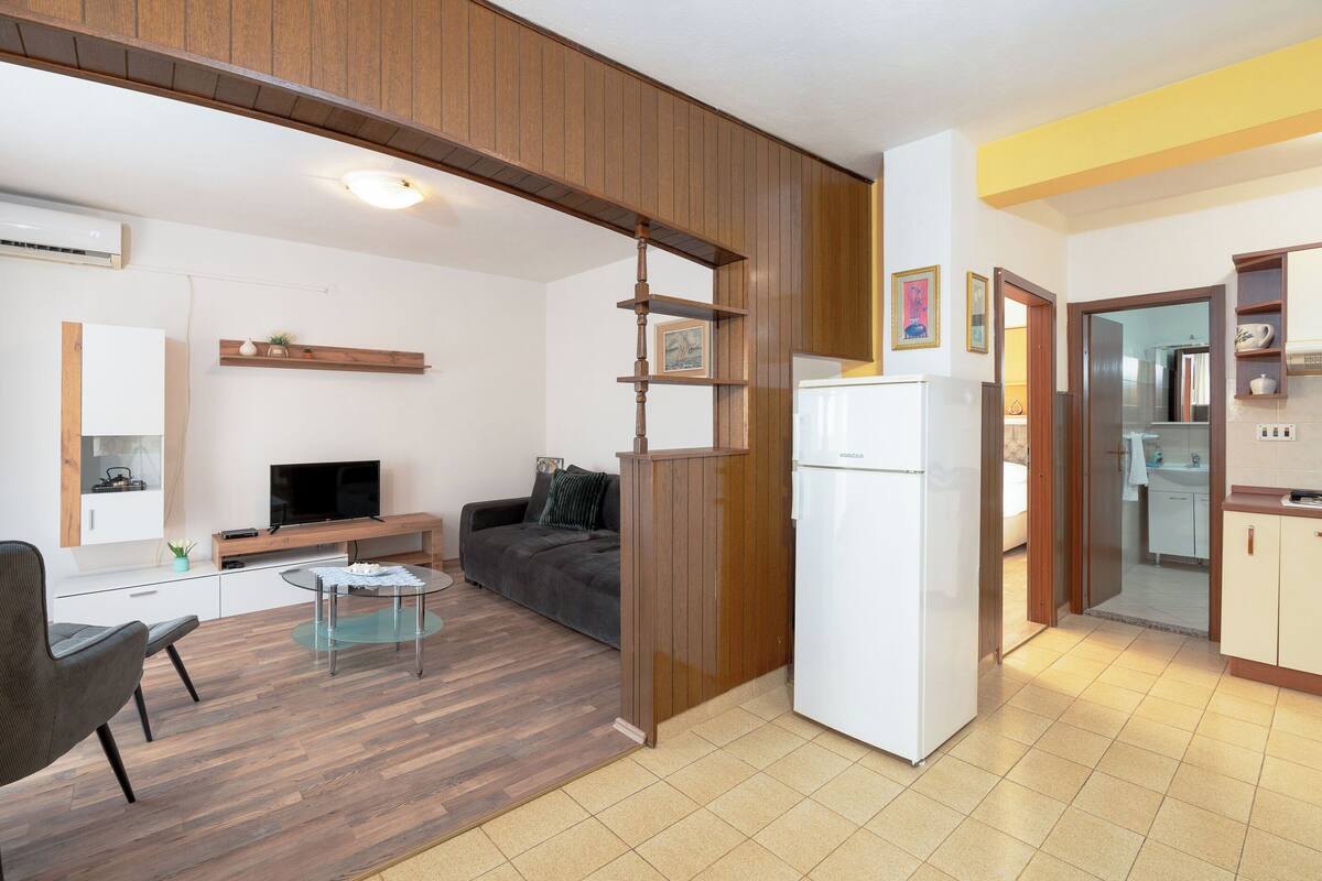 A modern apartment with a kitchen, dining area, and living room.