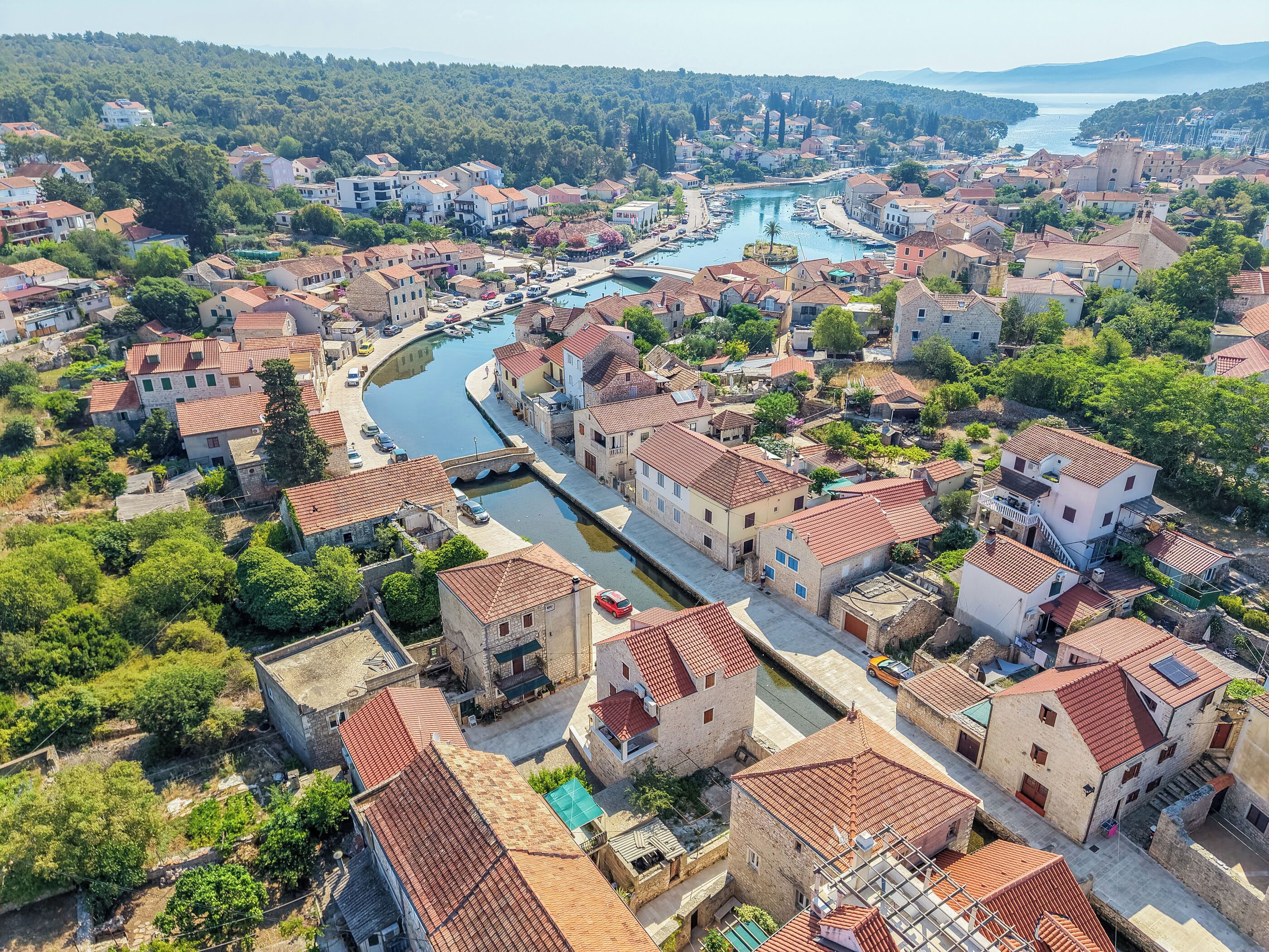 Uma cidade costeira com arquitetura tradicional, um porto de iates e um rio.