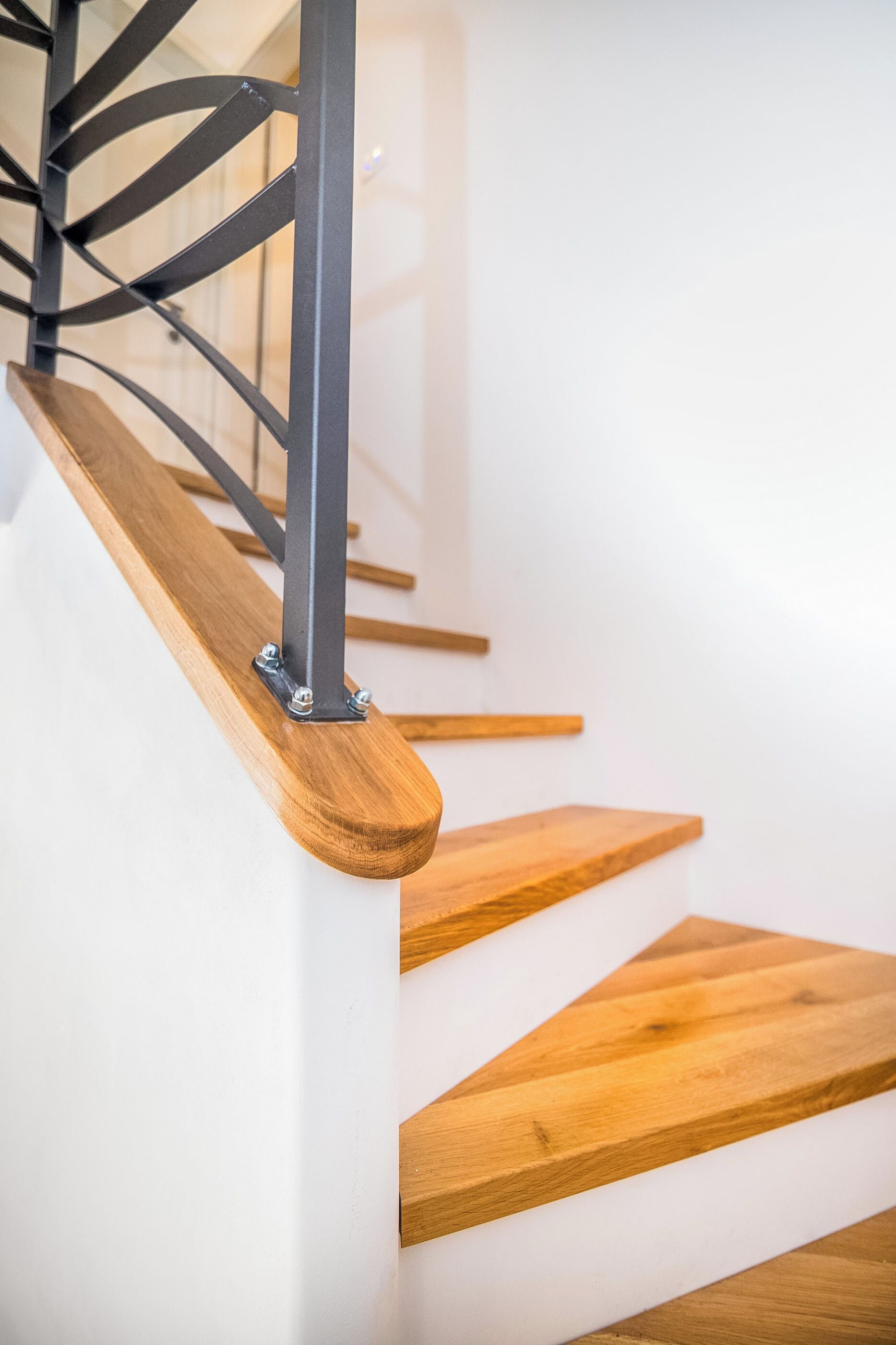 Un escalier moderne avec des marches en bois et des rampes en métal.