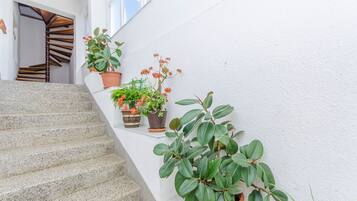 Eine Treppe mit Blumentöpfen und einer weißen Wand.
