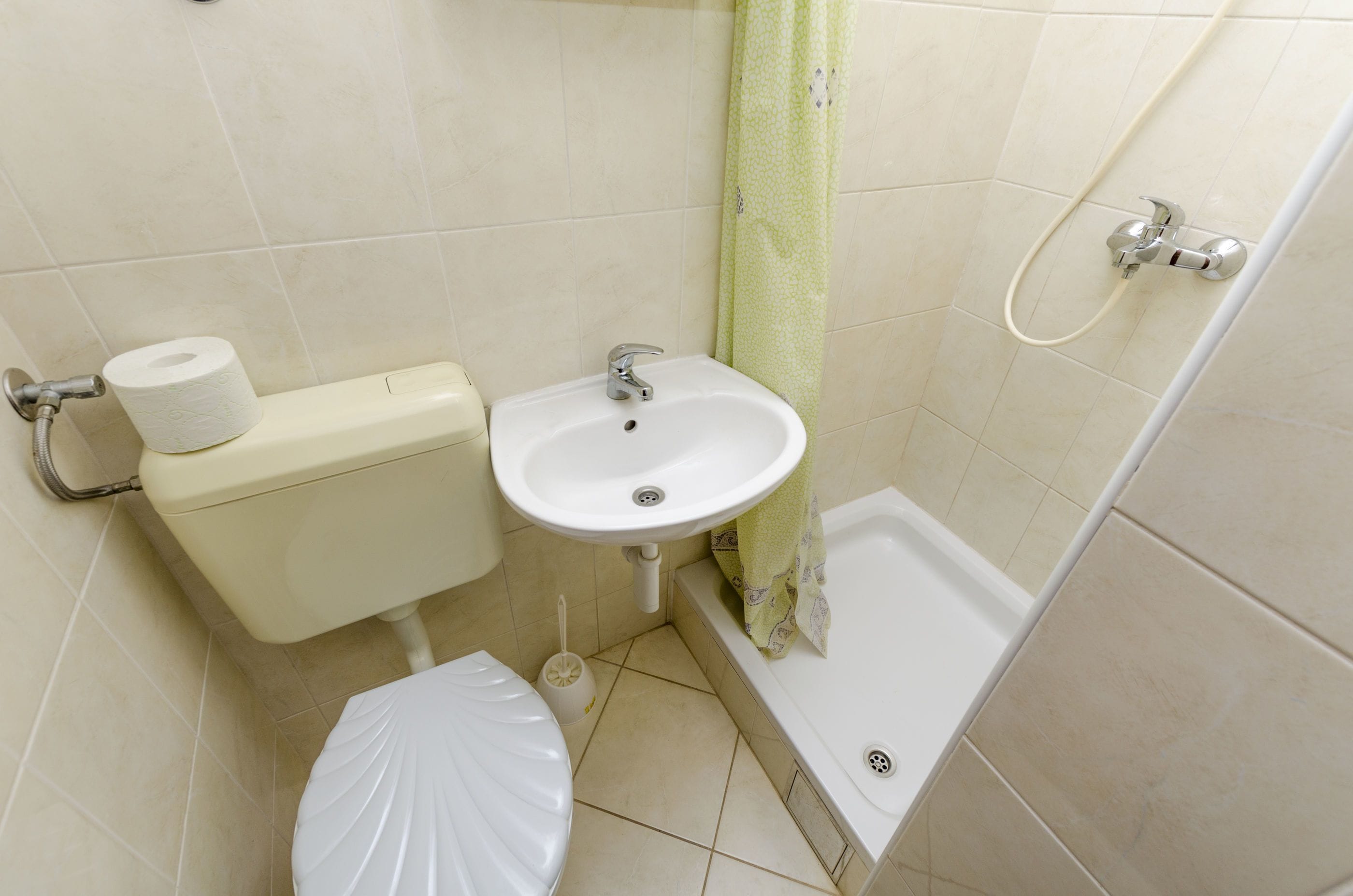 A bathroom with a toilet, sink, and shower.