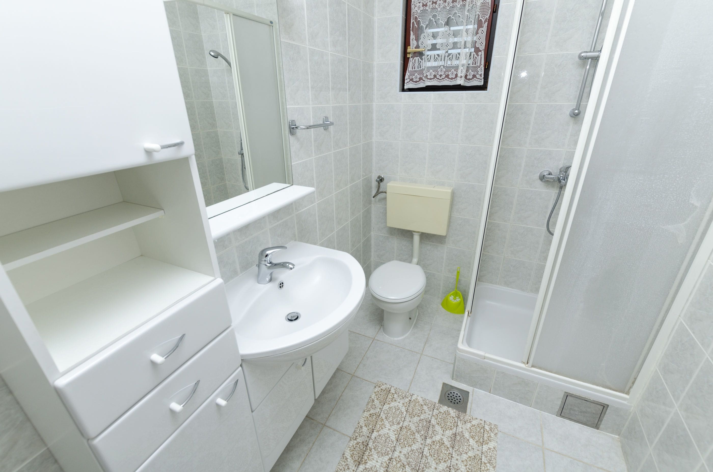 Ein modernes Badezimmer mit weißem Waschbecken, WC und Dusche.