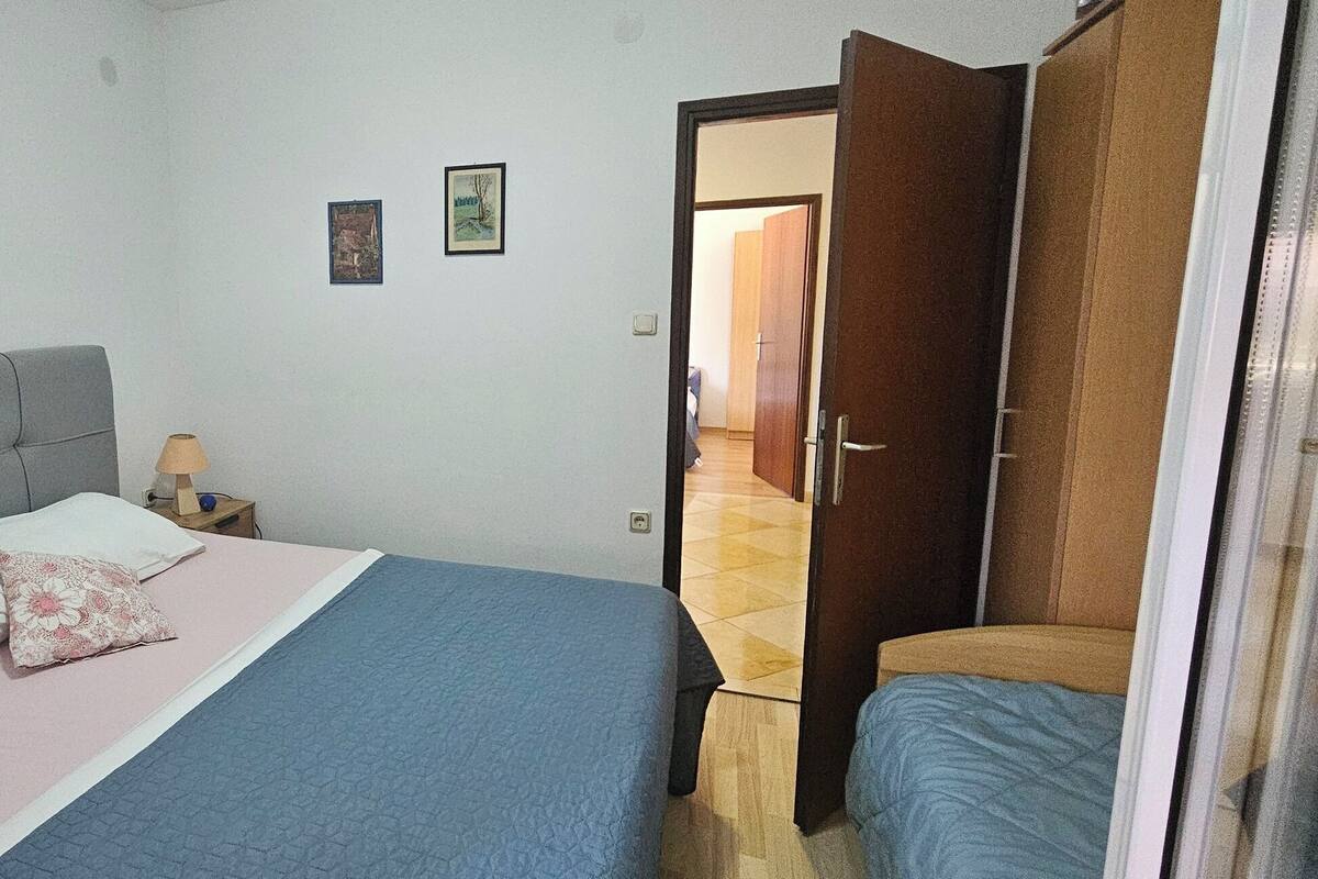 Une chambre à coucher avec un lit, une table de chevet, une lampe et une armoire.
