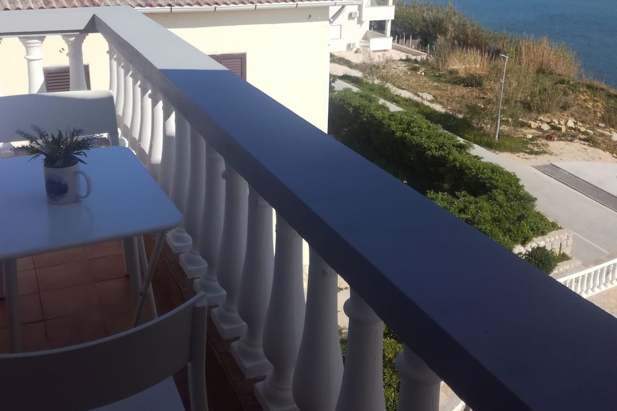 A balcony with a view of the sea and mountains.