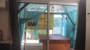 A room with a glass door, a wooden table, and a bench.