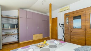 Un dormitorio con cama, armario de madera, bicicleta estática pequeña y bandeja de desayuno sobre la cama.