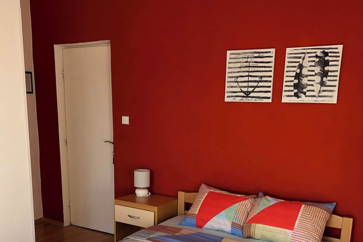 Habitación de hotel con una cama grande, dos mesitas de noche y una puerta.