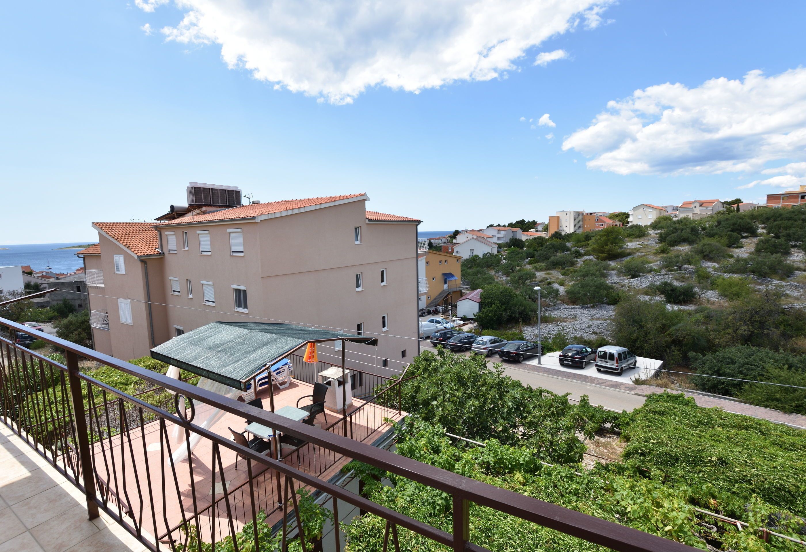 Un edificio residenziale con un balcone, una zona relax all'aperto e vista mare.